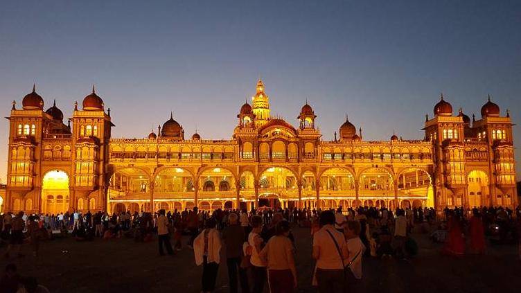The image shows the Mysore Palace by night.