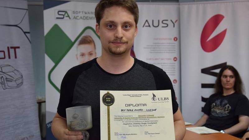 Here you can see an image of Alexander Frühwald holding the Best Paper Award.