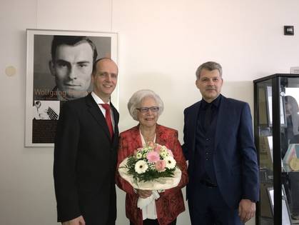 Präsident Prof. Dr. Robert Grebner und Dekan Prof. Dr. Peter Braun überreichen Frau Maria Fischer-Flach einen Blumenstrauß