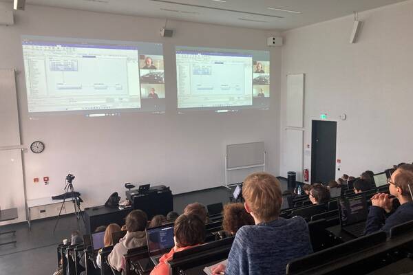 Teilnehmer verfolgen die Präsentation im Hörsaal H.1.1